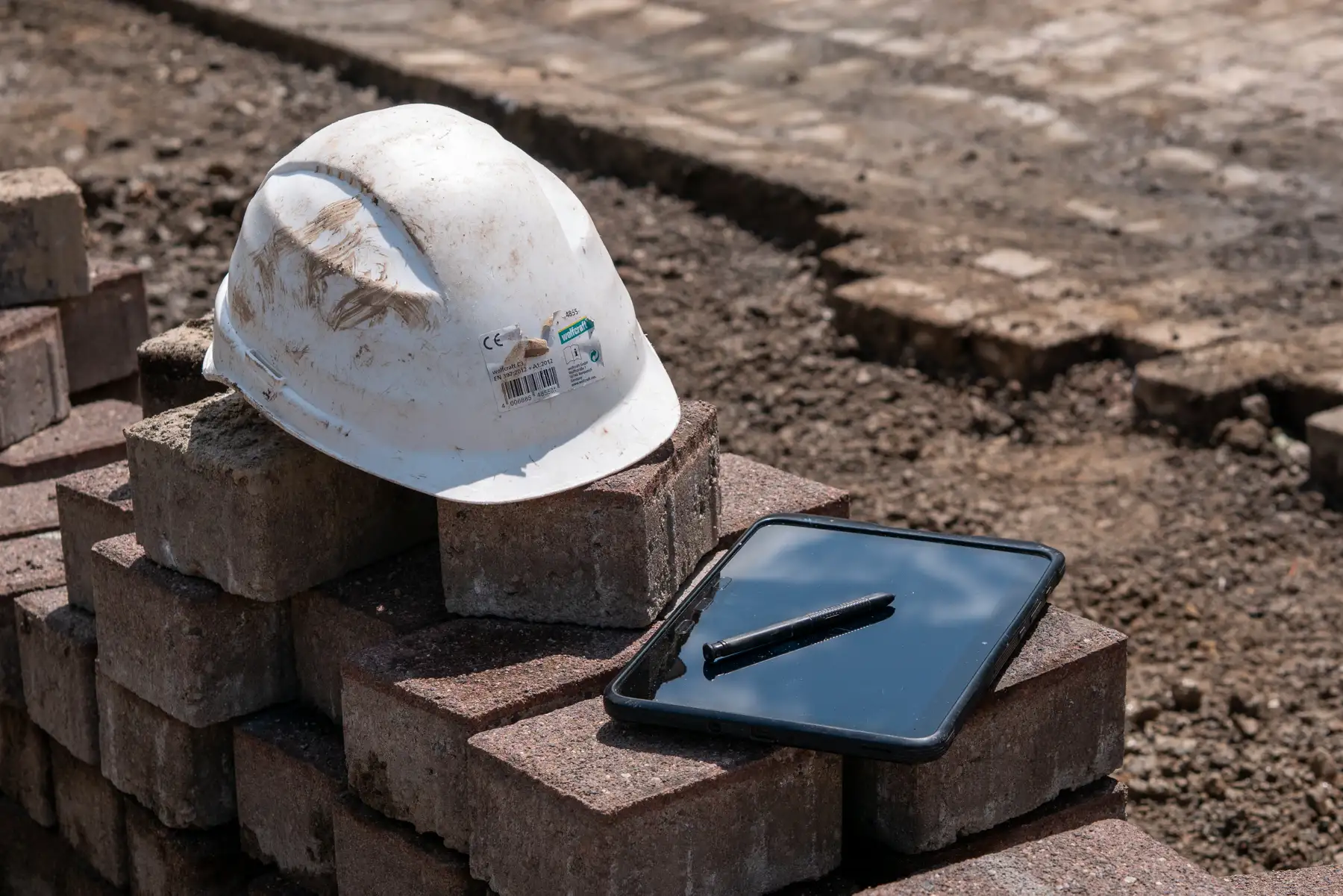 Bauhelm und Planungsunterlagen symbolisieren die sorgfältige Planung bei SBS Bauservice